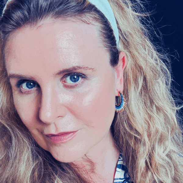 Woman with curly hair and blue earrings.